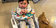 Aera is registered to the contest to win money with this photo: baby, baby_walker, teddy_bear, floor, tile_floor, playpen, blanket, toy, indoor, child, person, clothing, cute, infant, reaching, sitting, curious, soft_toy, home, nursery