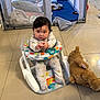 baby, baby_walker, teddy_bear, floor, tile_floor, playpen, blanket, toy, indoor, child, person, clothing, cute, infant, reaching, sitting, curious, soft_toy, home, nursery
