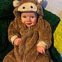Rowan is registered to the contest to win money with this photo: baby, child, costume, animal_costume, brown, fuzzy, smiling, cute, face, hood, horns, plush, green, yellow, sitting, portrait, indoor, clothing, happy, person
