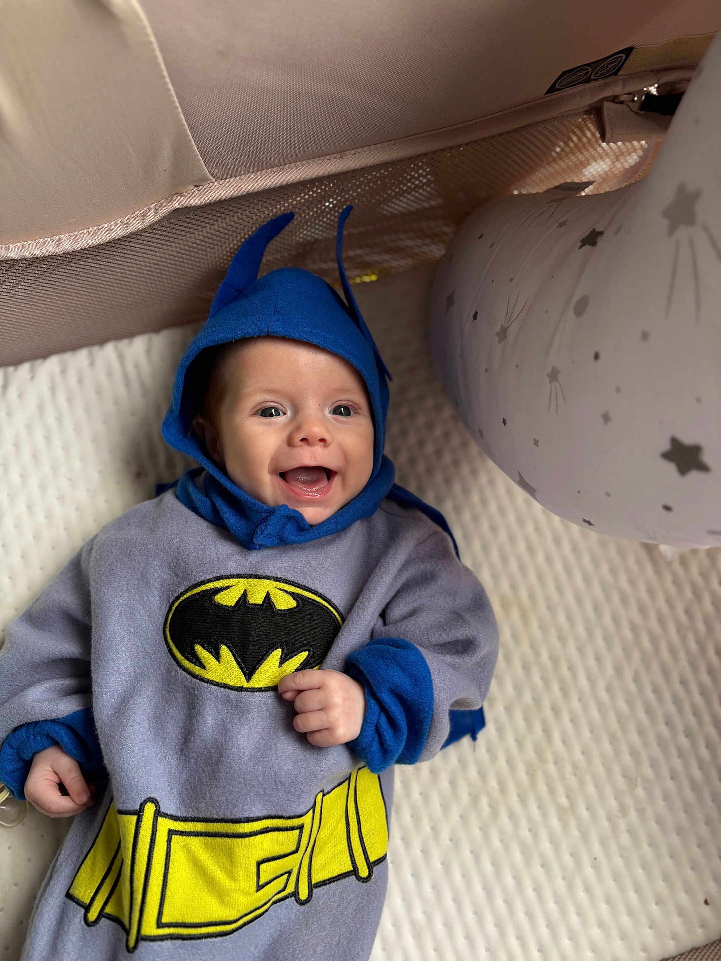 Rowan joined the competition — help win amazing prizes! baby, child, batman_costume, blue_hood, cape, smile, happy, infant, costume, superhero, pillow, stars, white_background, cute, portrait, lying_down, soft_texture, indoor, playful, clothing
