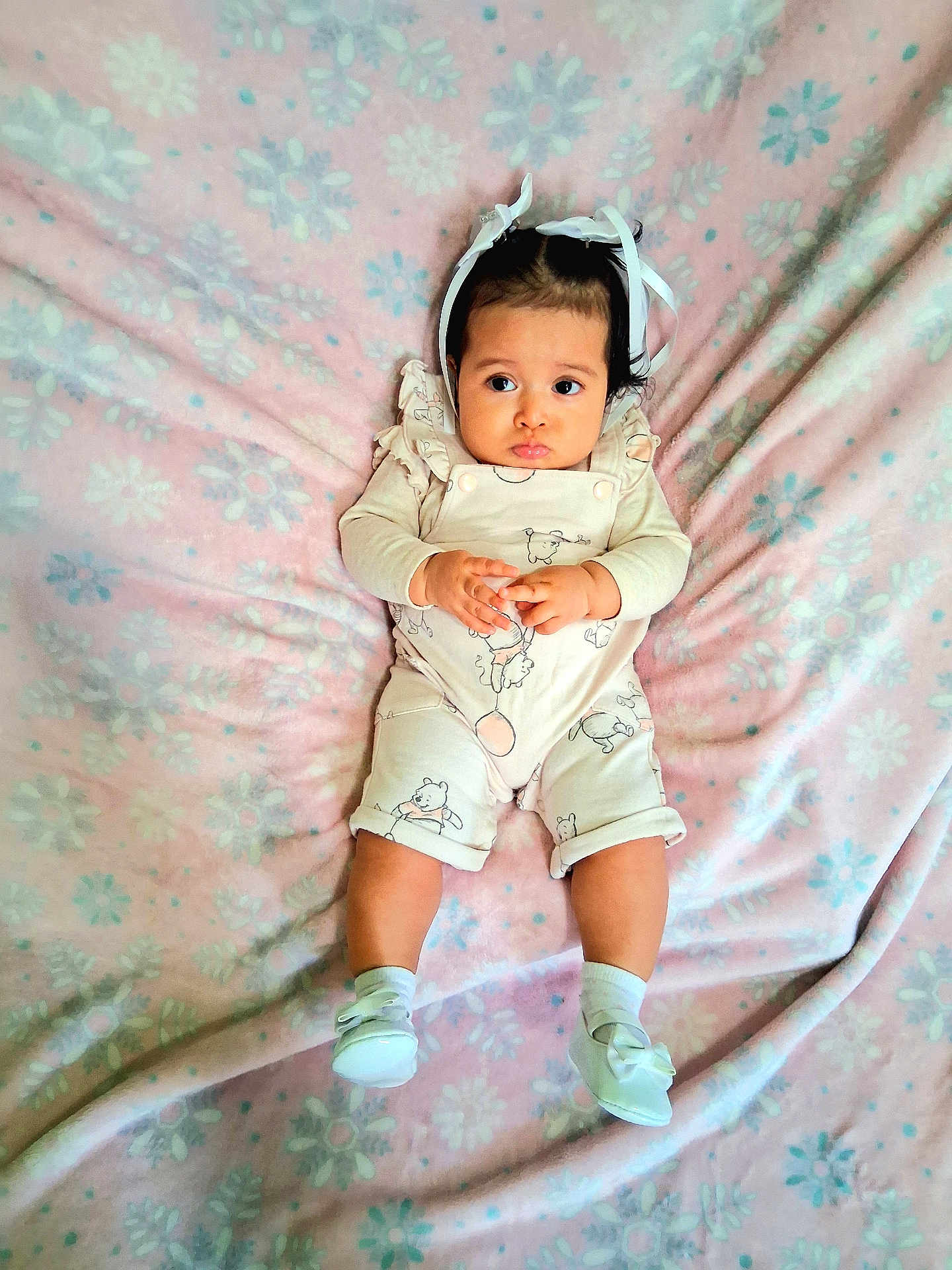 Jade joined the competition — help win amazing prizes! baby, infant, child, blanket, pink, floral_pattern, headband, ribbon, clothing, onesie, shoes, pout, cute, lying_down, soft_texture, indoors, portrait, adorable, small_hands, expression