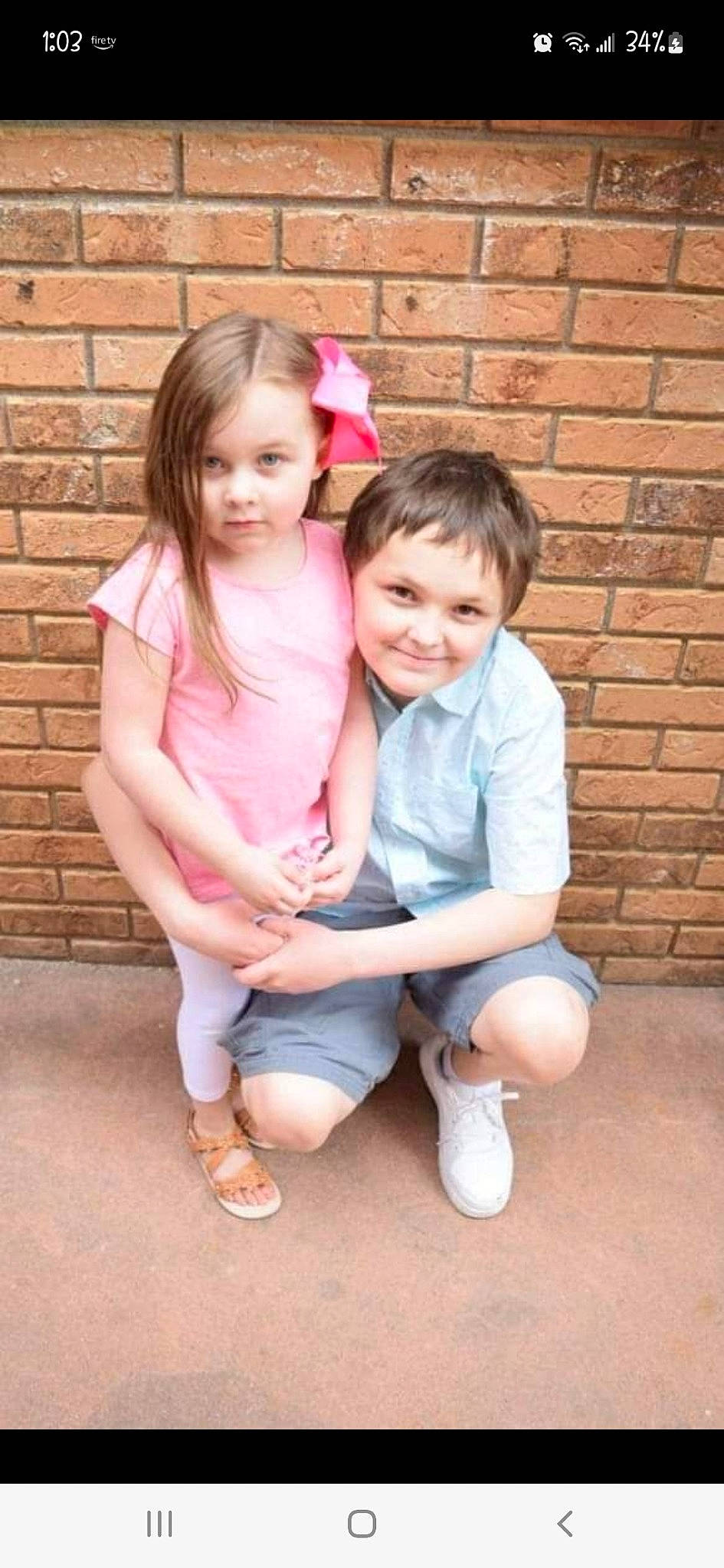 Gabriella is registered to the contest to win money with this photo: baby_toddler_clothing, brick, brickwork, event, eye, face, footwear, gesture, grass, happy, head, iris, joy, leg, person, pink, shoe, smile, sneakers, standing