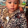 toddler, child, jacket, leopard_print, minnie_mouse, indoor, face, portrait, fur_collar, curly_hair, young_child, clothing, zipper, standing, home, expressionless, person, casual_wear, cute, young_kid