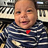 baby, child, smiling, striped_clothing, heart, keyboard, musical_instrument, cute, portrait, indoor, happy, young_child, face, blue_eyes, curly_hair, infant, closeup, person, music, expression
