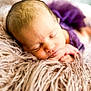 newborn, baby, sleeping, purple_clothing, fluffy_blanket, soft_texture, peaceful, infant, portrait, closeup, head, face, resting, cute, young_child, hands, skin, cozy, warm, indoor