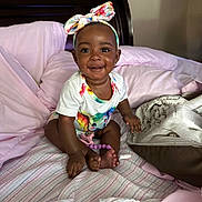 Kymbrielle joined the competition — help win amazing prizes! baby, child, smiling, headband, onesie, unicorn, bed, blanket, pillow, indoor, infant, cute, happy, person, skin, foot, hand, furniture, clothing, portrait