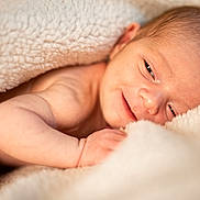 Lucas participe au concours pour gagner de l'argent avec cette photo : newborn, baby, infant, blanket, smile, face, skin, arm, hand, soft, cozy, warm, cute, sleepy, portrait, closeup, resting, comfort, tender, peaceful
