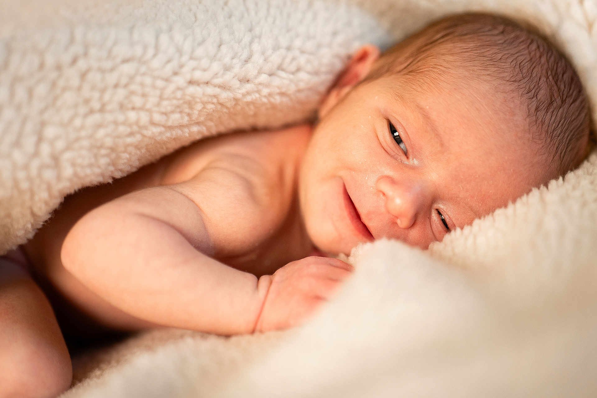 Lucas participe au concours pour gagner de l'argent avec cette photo : newborn, baby, infant, blanket, smile, face, skin, arm, hand, soft, cozy, warm, cute, sleepy, portrait, closeup, resting, comfort, tender, peaceful