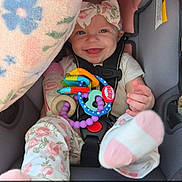 Ainsley joined the competition — help win amazing prizes! baby, car_seat, smiling, toy, blanket, bottle, headband, floral_pattern, pajamas, child, cute, happy, infant, colorful, seatbelt, indoors, portrait, footwear, soft_toy, playtime