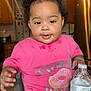Ariya joined the competition — help win amazing prizes! baby, cabinet, child, counter, curly_hair, cute, donut_graphic, drink, face, hair_buns, happy, indoor, kitchen, person, pink_shirt, refrigerator, smiling, table, toddler, water_bottle