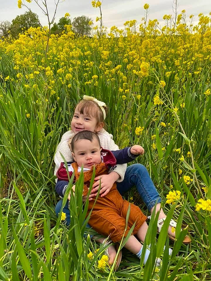 Reyna is registered to the contest to win money with this photo: agriculture, cloud, ecoregion, flower, flowering_plant, grass, grass_family, grassland, green, happy, joy, meadow, natural_environment, natural_landscape, people_in_nature, person, plant, sky, summer, toddler