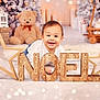 baby, child, smile, holiday, christmas, noel, wooden_letters, star, teddy_bear, decorations, candles, festive, indoors, soft_surface, happy, portrait, cute, seasonal, celebration, background