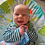Oscar is registered to the contest to win money with this photo: baby, smile, infant, blanket, striped_clothing, baby_seat, pattern, colorful, happy, cute, child, indoor, face, hands, soft_toy, clothing, young_child, comfort, playful, seat