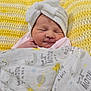 baby, blanket, cozy, crochet, cute, face, headwear, indoors, infant, knitted, newborn, pattern, resting, sleeping, smiling_face, soft, towel, white, wrapped, yellow