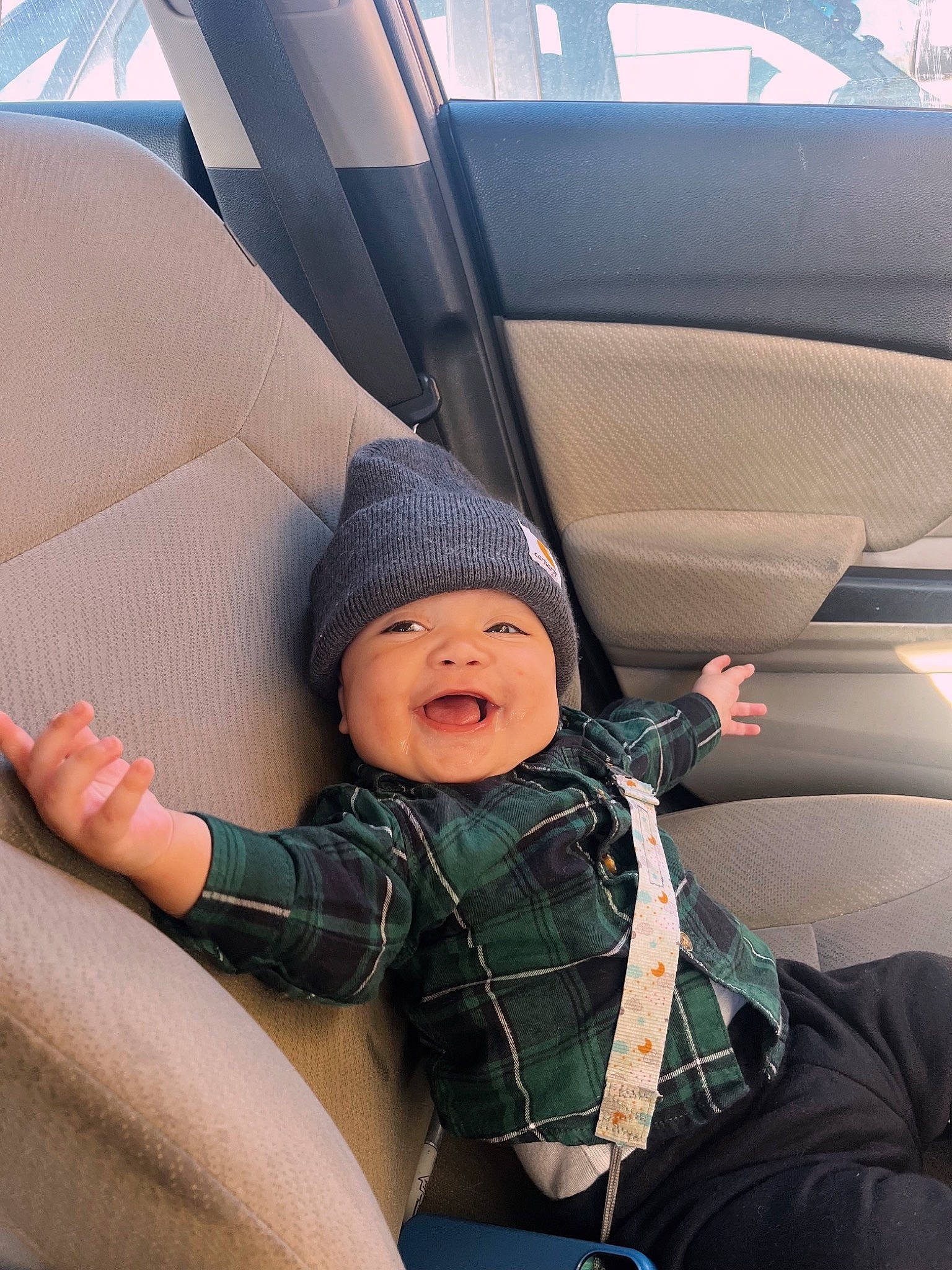 Bentley is registered to the contest to win money with this photo: auto_part, automotive_design, automotive_exterior, baby, car, car_seat, car_seat_cover, child, comfort, family_car, happy, headwear, luxury_vehicle, motor_vehicle, person, personal_luxury_car, smile, tints_and_shades, toddler, tree