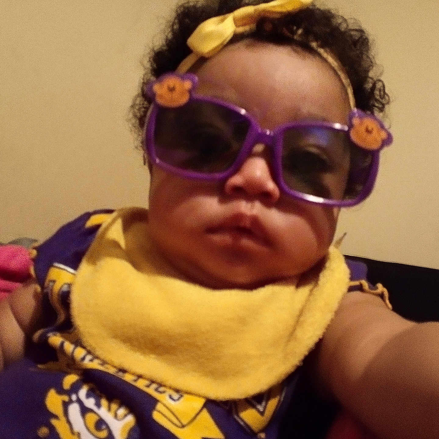 Damiria Wiggins is registered to the contest to win money with this photo: baby, infant, child, portrait, selfie, sunglasses, purple_sunglasses, headband, yellow_bow, scarf, curly_hair, serious_expression, sitting, indoor, couch, clothing, fashion, closeup, face, person