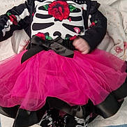 Callie a rejoint le concours — aidez-le/la à gagner de superbes lots ! baby, infant, tutu, pink_skirt, skeleton_outfit, red_rose, black_shoes, white_shoes, patterned_socks, lying_down, blanket, bow, cute, child, fashion, footwear, clothing, portrait, indoors, soft_toys