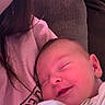 baby, child, closeup, clothing, comfort, couch, cozy, fabric, face, head, indoors, peaceful, person, pink, resting, sleeping, smile, soft, warm, young