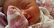 Aurora joined the competition — help win amazing prizes! baby, child, closeup, cozy, cute, face, floral_pattern, hand, indoors, infant, mittens, newborn, onesie, person, pillow, rainbow_pattern, resting, sleeping, smile, soft