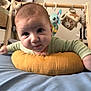 Ezra participe au concours pour gagner de l'argent avec cette photo : baby, infant, pillow, bed, toy, soft_toys, blue_bedspread, mustard_pillow, curious, face, person, child, indoors, furniture, wooden_frame, play_gym, cute, closeup, reaching, expression