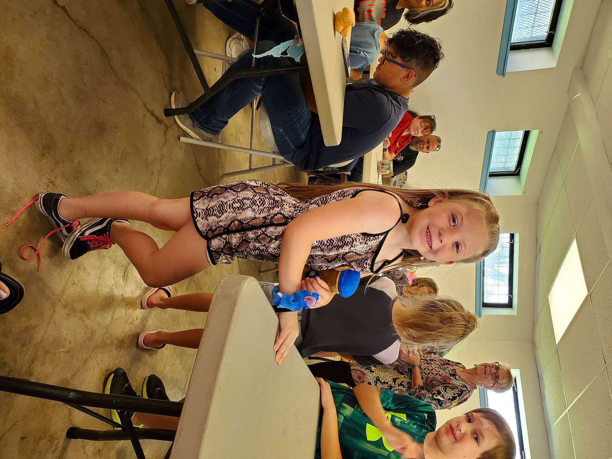 Delaney is registered to the contest to win money with this photo: elbow, event, eyewear, fashion_design, finger, foot, fun, gesture, happy, human_leg, joint, joy, knee, leisure, person, picture_frame, room, shoulder, thigh, visual_arts