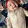 baby, infant, smile, headband, onesie, heart_pattern, arrow_pattern, floral_blanket, lying_down, cute, happy, child, portrait, indoors, soft_lighting, closeup, person, skin, hand, face