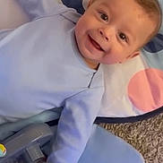 Dash joined the competition — help win amazing prizes! baby, child, smiling, blue_clothing, play_mat, carpet, indoor, person, happy, infant, cute, lying_down, toy, colorful, young_child, face, head, hand, playful, expression