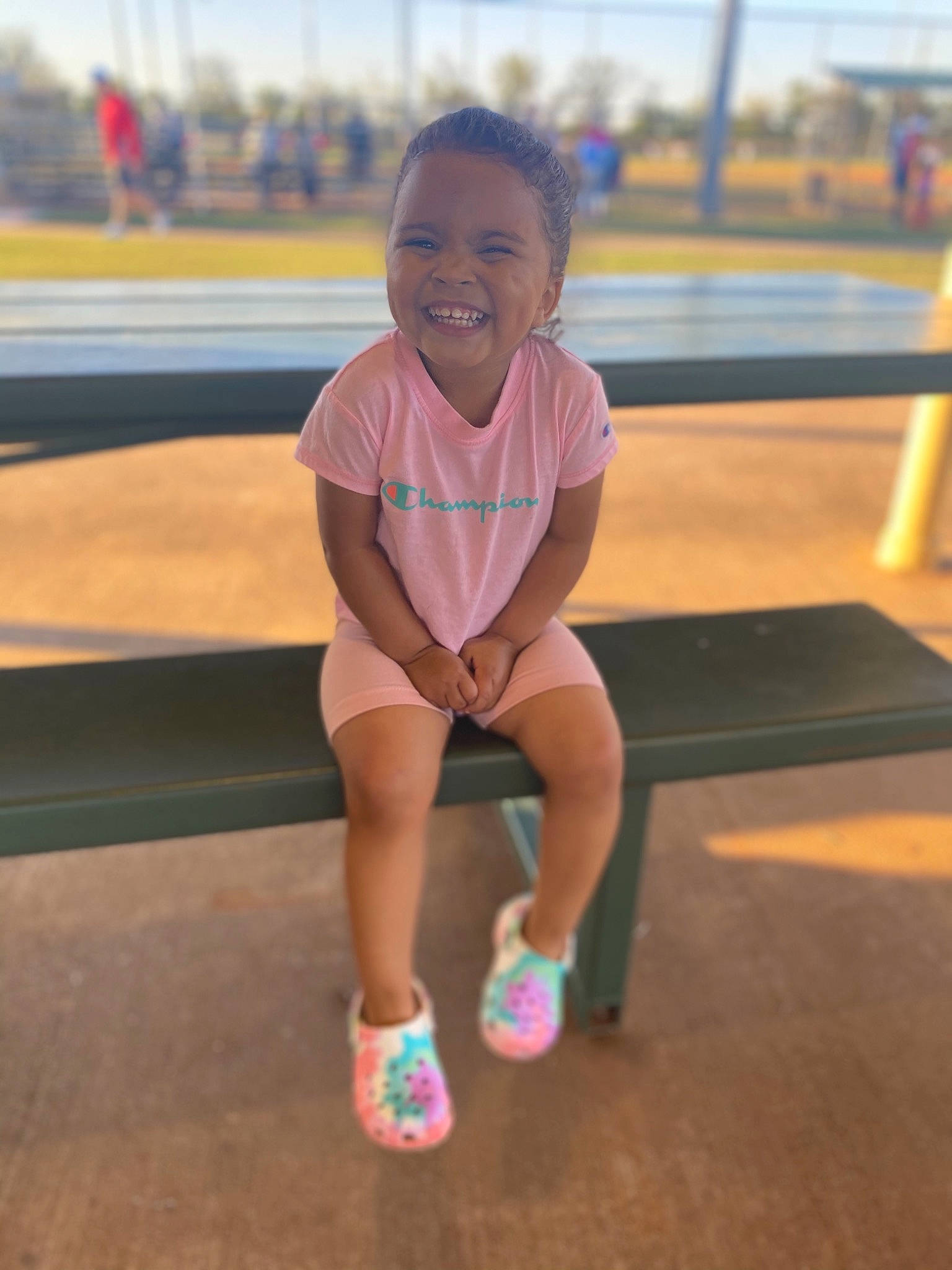 Milani is registered to the contest to win money with this photo: blond, child, city, face, fun, grass, happy, human_leg, joy, leisure, magenta, person, physical_fitness, playground, recreation, sitting, sky, smile, thigh, toddler