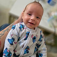 Eden participe au concours pour gagner de l'argent avec cette photo : baby, infant, smile, onesie, clothing, person, arm, tattoo, face, happy, indoor, holding, cute, child, apparel, pattern, portrait, baby_clothes, closeup, soft_focus