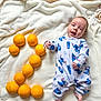 Eden participe au concours pour gagner de l'argent avec cette photo : baby, infant, onesie, stitch, orange, fruit, blanket, smile, happy, cute, foot, hand, number_two, soft, bedroom, celebration, lying_down, playful, child, indoors
