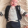 Eden participe au concours pour gagner de l'argent avec cette photo : baby, infant, smiling, blanket, clothing, navy_jacket, striped_shirt, pants, socks, lying_down, happy, cute, portrait, child, soft_texture, hand, indoors, cozy, comfortable, person