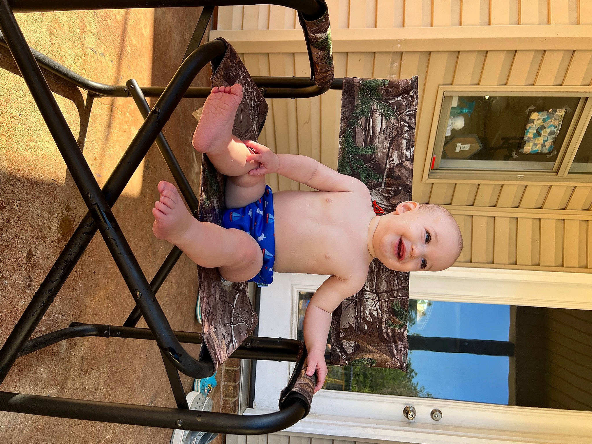 Thomas is registered to the contest to win money with this photo: abdomen, barechested, barefoot, chest, child, foot, fun, happy, human_leg, joy, knee, leisure, person, recreation, shorts, sitting, swing, thigh, toddler, trunk
