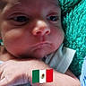 arm, baby, child, close_up, cute, expression, face, flag_emoji, green_background, hand, indoors, infant, newborn, peaceful, person, portrait, resting, skin, soft_lighting, texture