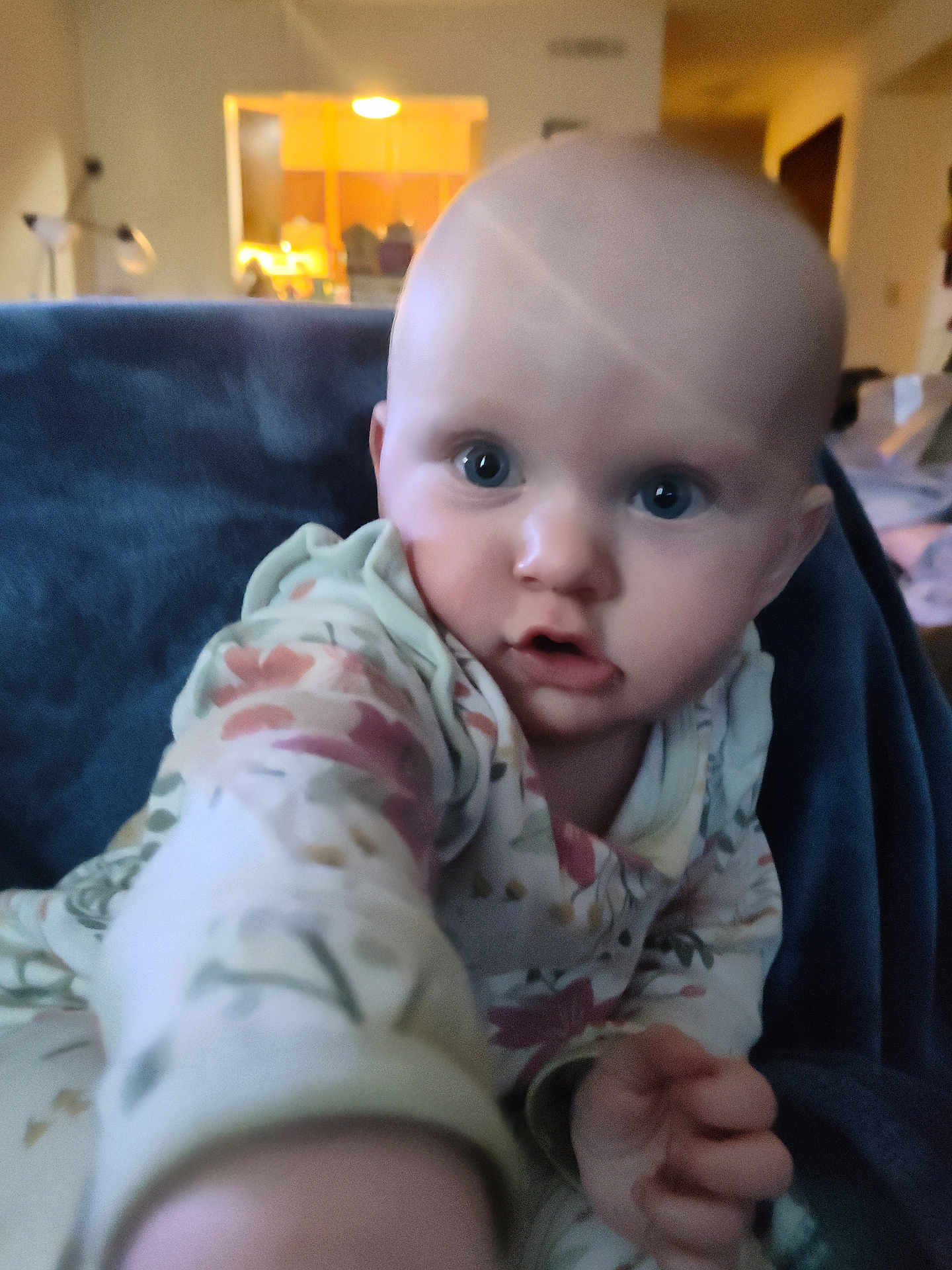 Aurora is registered to the contest to win money with this photo: baby, child, infant, face, hand, onesie, floral_pattern, blue_blanket, indoor, home, curious, wide_eyes, portrait, soft_lighting, closeup, couch, furniture, person, young, cute