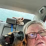 Lady is registered to the contest to win money with this photo: animal, backseat, car, casual, closeup, companion, dog, expression, friendship, glasses, headrest, inside, leisure, pet, playful, portrait, seat, spontaneous, towel, woman