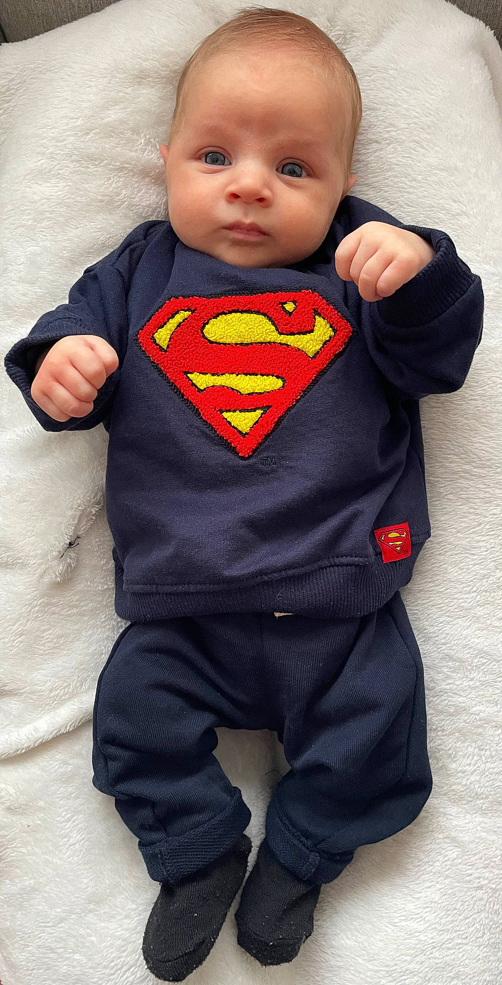 Mayron a rejoint le concours — aidez-le/la à gagner de superbes lots ! adorable, baby, baby_fashion, blanket, blue_clothing, casual_wear, child, closeup, cute, fist, indoor, infant, lying_down, portrait, resting, small_hands, socks, soft_texture, superman_logo, young_child