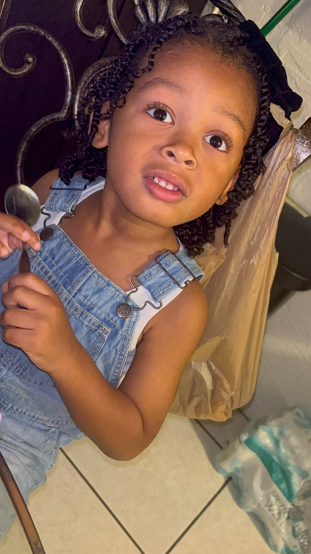 Dakari is registered to the contest to win money with this photo: blackhair, bodypart, child, clothing, cutlery, face, female, finger, girl, hair, hand, happy, head, pants, person, photography, portrait, sitting, smile, spoon