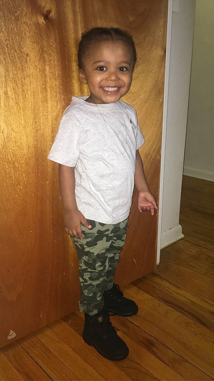 Kyaire joined the competition — help win amazing prizes! arm, baby_toddler_clothing, face, flooring, hardwood, human_body, human_leg, joy, knee, leg, military_camouflage, person, sleeve, smile, standing, t_shirt, thigh, toddler, trunk, waist