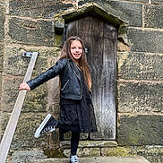 Raluca joined the competition — help win amazing prizes! black_dress, black_jacket, casual_clothing, child, daylight, fashion, girl, happy, long_hair, outdoor, playful, portrait, railing, smile, sneakers, standing, steps, stone_wall, wooden_door, young_person
