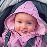baby, child, hood, jacket, pink, polka_dot, smile, tongue, stroller, blanket, face, person, outdoor, cute, happy, infant, clothing, seatbelt, warm, portrait