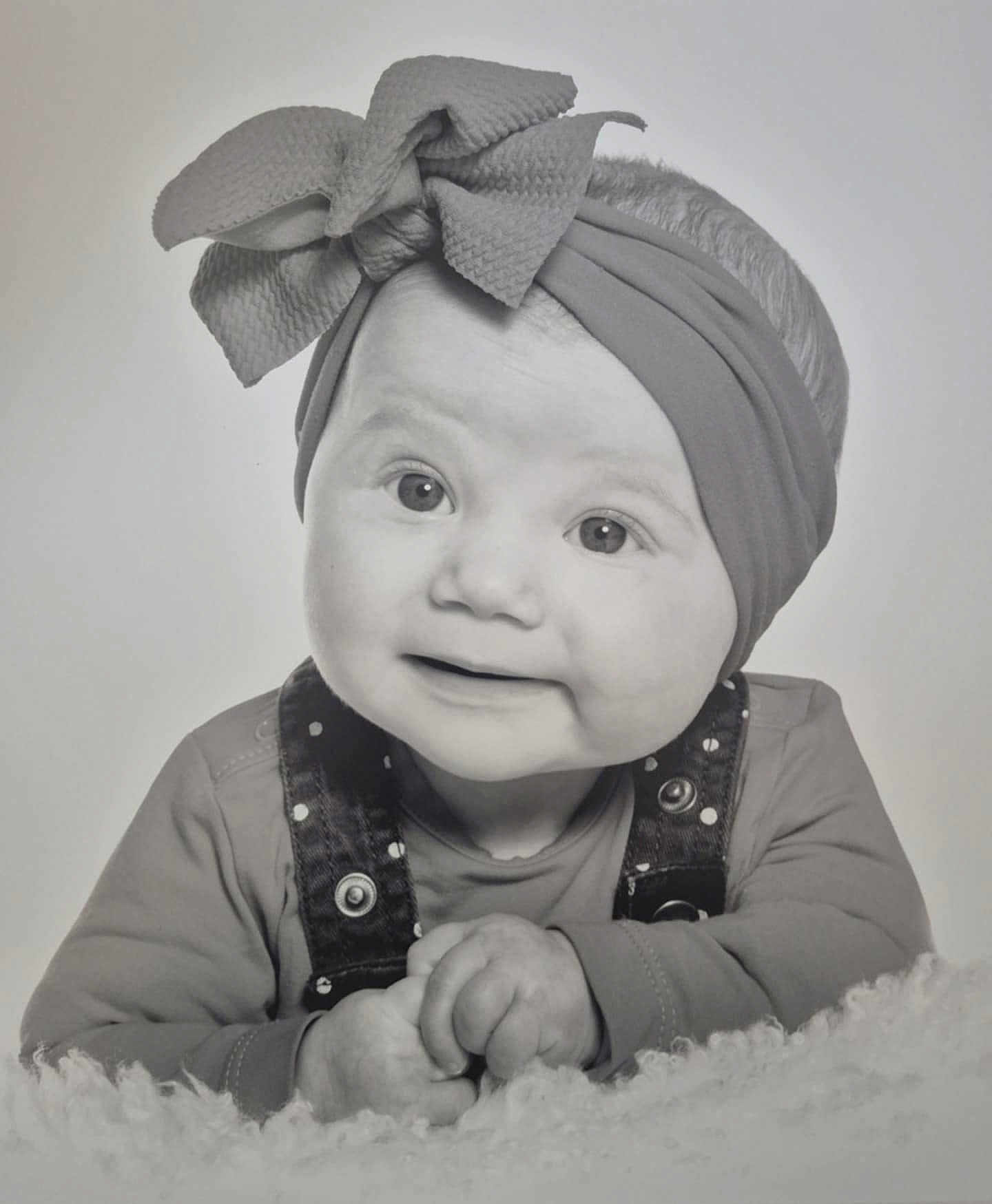 Eïza participe au concours pour gagner de l'argent avec cette photo : baby, child, headband, bow, denim_overalls, smile, hands, portrait, black_and_white, soft_focus, fuzzy_blanket, cute, infant, clothing, face, eyes, happy, studio, closeup, baby_girl