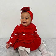 Chloe is registered to the contest to win money with this photo: baby, blanket, bows, child, cozy, cute, fashion, flower, girl, happy, headband, indoors, knitwear, playful, portrait, red_clothing, sitting, smiling, toddler, white_tights