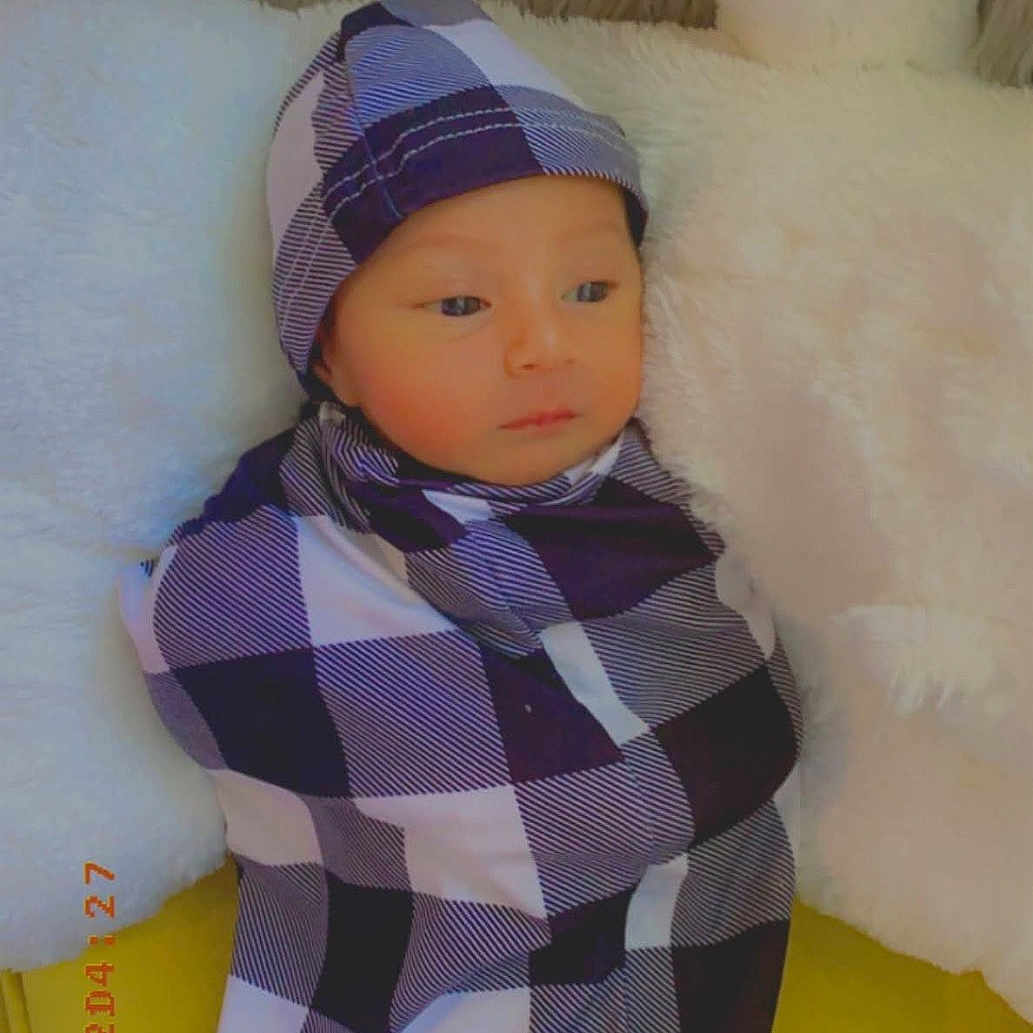 Jad joined the competition — help win amazing prizes! baby, blanket, checkered_pattern, child, clothing, cozy, cute, face, hat, indoors, infant, newborn, person, pillow, portrait, resting, sleepy, soft_texture, wrapped, yellow_background