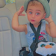 Jad joined the competition — help win amazing prizes! toddler, child, car_seat, hat, plush_toy, penguin, seatbelt, car_interior, curious, blue_sleeveless_shirt, sitting, safety, cute, young_child, window, daylight, portrait, innocent, casual_clothing, small_person