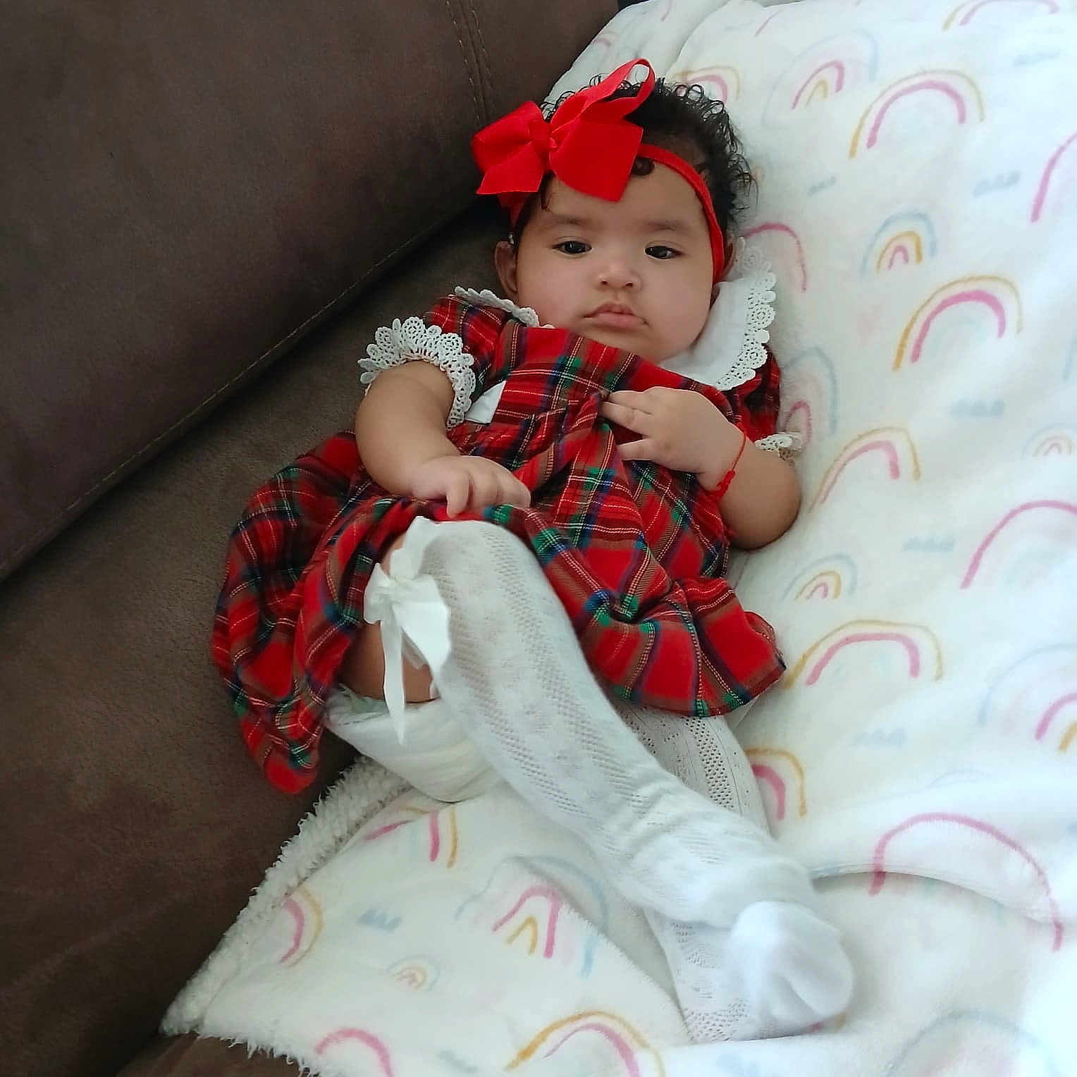 Jesmy joined the competition — help win amazing prizes! baby, infant, girl, red_bow, plaid_dress, white_tights, blanket, rainbow_pattern, couch, cozy, cute, headband, lace, child, portrait, indoors, sitting, soft, furniture, person