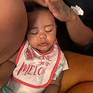 Ramiya is registered to the contest to win money with this photo: baby, infant, bib, sleeping, hands, tattoo, pacifier, closeup, skin, cute, child, person, soft_light, peaceful, clothing, portrait, indoor, love, family, tender