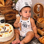 Alan Guara is registered to the contest to win money with this photo: baby, child, infant, chef_hat, apron, bakery, bread, cake, birthday, nine_months, flour, spoon, sitting, portrait, food, pastry, indoor, smiling, decor, photography