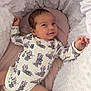 baby, infant, smile, onesie, minnie_mouse, pattern, cushion, soft, cozy, cute, child, lying_down, clothing, happy, face, skin, head, arm, leg, blanket
