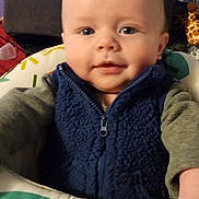 Jameson joined the competition — help win amazing prizes! baby, child, infant, smile, face, blue_vest, fleece, baby_seat, toy, giraffe, hand, indoor, lamp, neon_light, window, curtain, blanket, colorful, cozy, portrait