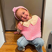 Hina participe au concours pour gagner de l'argent avec cette photo : child, girl, smiling, pink_knitwear, headband, stairs, wooden_floor, blue_jeans, happy, cute, portrait, casual_clothing, indoors, person, fashion, playful, young_child, socks, blonde_hair, accessory